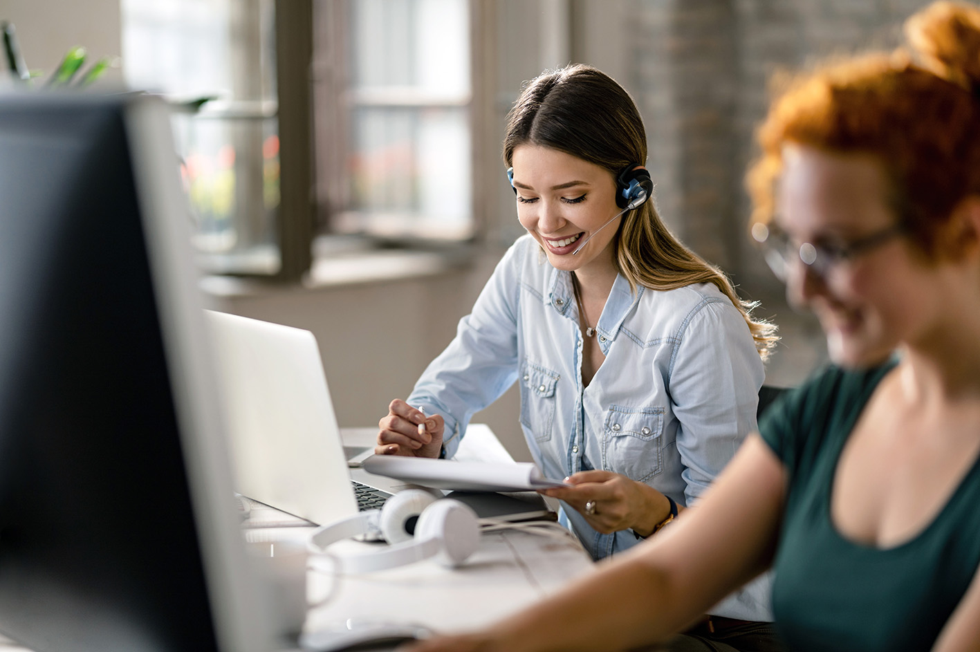 ecotel SIP-Trunk to go Vorschaubild, Frau telefoniert über Headset im Büro